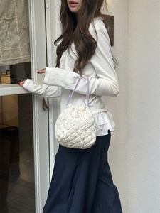 Detailed view of quilted floral bucket bag with purple drawstring on a white background