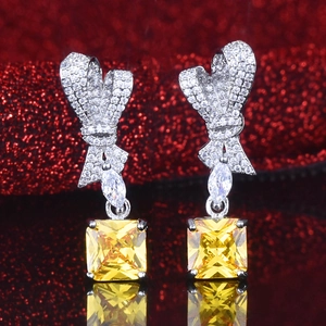 Radiant cut yellow diamond drop earrings with silver bow design for high-end jewelry style