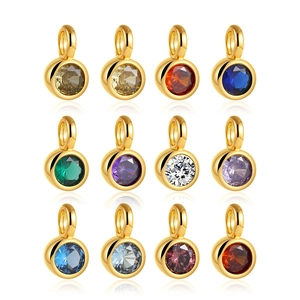 Macro display of 12 gold plated birthstone pendants with colorful round cut crystals