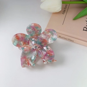 Detailed view of flower hair claw with colorful marble acetate texture and glossy finish