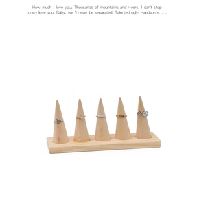 Detail of five-tier wooden ring display stand with natural wood cones on a rectangular base