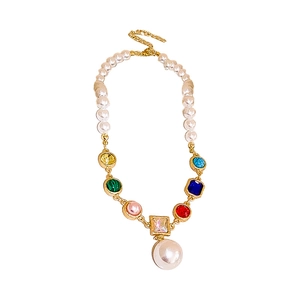 Colorful crystal and pearl beaded necklace with a large pearl pendant on white background