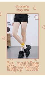 Detail of yellow and white heart pattern cotton socks paired with black sneakers