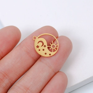 Close-up of small gold stainless steel sun and moon celestial pendant charm for DIY