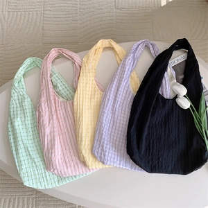 Detail of macaron-colored tote bags showing waffle weave texture and pastel fabric colors