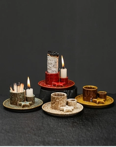 Detail view of four colorful ceramic incense holders with glazed texture and candle tray