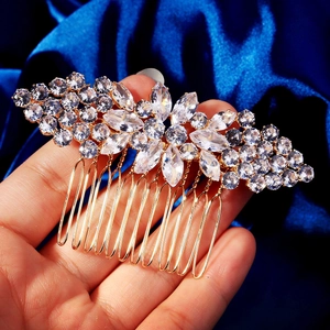 Detail of crystal floral hair pin with gold leaf clusters on blue velvet background