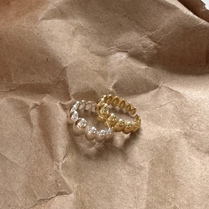 Close-up of gold and silver bubble style minimalist rings on a kraft paper background