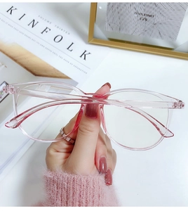 Detail of trendy pink transparent oversized eyewear frame held by hand for style