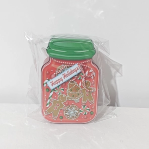 Detail of Christmas tin box shaped like a jam jar with gingerbread man and candy cane patterns