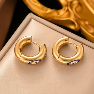 Créoles dorées exotiques avec motifs d'yeux en émail bleu sur un coffret à bijoux