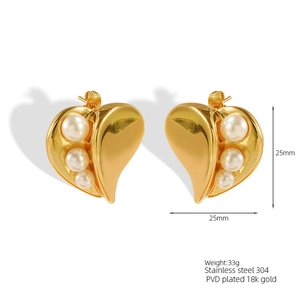 Gros plan sur des boucles d'oreilles cœur en acier inoxydable doré à l'or 18 carats et perles