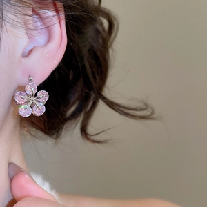Close-up of pink zircon flower earrings worn by model, showing refined sparkle