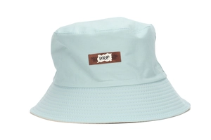 Detail of light blue cotton bucket hat with brown leather label and reinforced brim