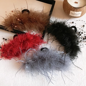 Detailed view of large feather claw clips with elegant pearls in four different colors