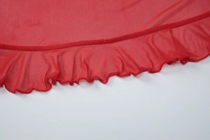 Détail de maille rouge montrant l'ourlet à volants plissé et la texture de couture fine