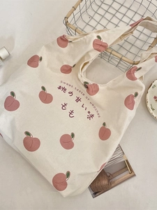 Beige canvas tote bag with peach prints and Sweet taste of peaches text on flat lay