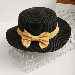 Elegant black flat-top wide brim straw hat with yellow striped bow on white grid