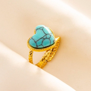 Detailed macro of gold twisted metal ring featuring a heart-shaped turquoise stone inlay