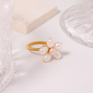 Detail of handmade gold wire ring featuring white and pink freshwater pearl flower