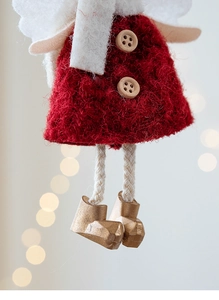 Macro shot of plush Christmas angel ornament with red knit skirt and golden boots detail