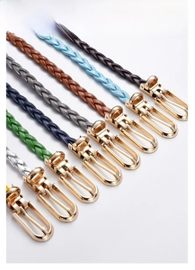 Close-up of multicolored braided PU leather belts with gold U-shaped metal pin buckles