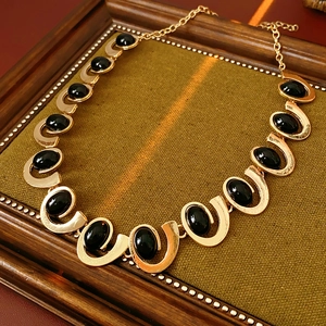 Vue détaillée du collier à maillons en U dorés orné de pierres précieuses ovales noires