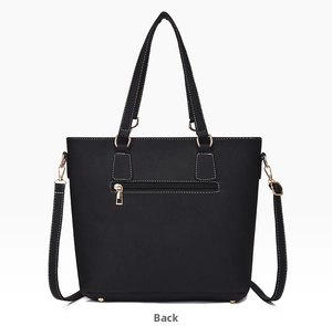 Detail of the back of black litchi leather tote bag with a gold zipper pocket