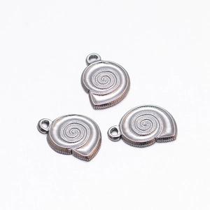 Detailed macro view of three silver shell pendants with spiral texture and metal rings
