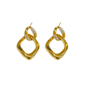 Cerchi dorati intrecciati con cristalli di zirconia e design metallico a spirale lucida