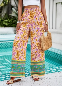 Détail du pantalon bohème à taille haute et jambe large avec imprimés floraux rose et orange