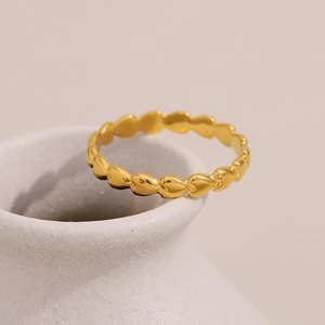 Detail shot of the continuous 18K gold plated heart patterns on a minimalist ring