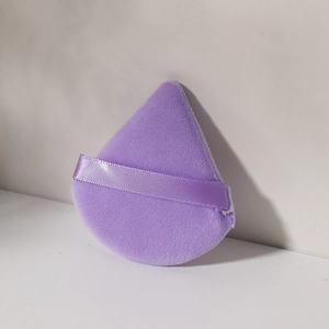 Detalle de una borla de algodón suave violeta en forma de gota con cinta de agarre