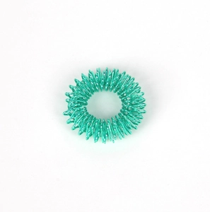Close-up of a turquoise metallic spring massage ring for finger acupressure and stress relief
