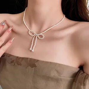 Elegant French style pearl necklace with bow pendant on a model's neck for women