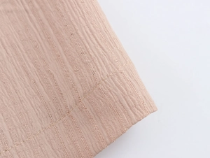 Gros plan du tissu beige texturé avec des détails de couture sur le vêtement