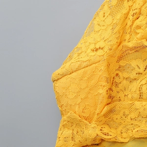 Primo piano della pizzo giallo brillante con intricati motivi floreali ricamati