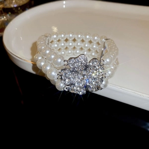 Macro shot of multi-layer pearl bracelet with sparkling clover rhinestone buckle