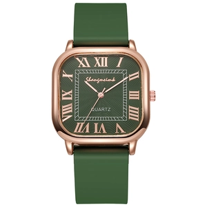 Détail d'une montre carrée en or rose avec cadran vert ondulé et chiffres romains