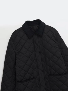 Detail der schwarzen Steppjacke mit Cordkragen und Rautenmuster-Textur