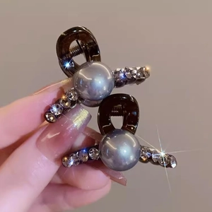 Elegant small pearl and rhinestone hair clips for women shown in a detailed hand-held view