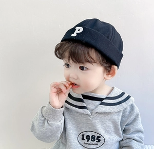 Detail of a child wearing a black letter P beanie and a grey sailor collar sweatshirt