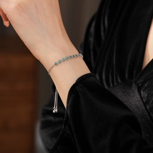Close-up of sparkling green zircon clover bracelet with adjustable silver sliding buckle