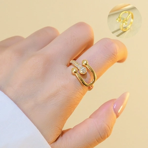 Detail of gold horseshoe ring with micro-paved cubic zirconia worn on model finger