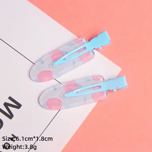 Detail of light blue metal hair clip with pink dot pattern, 6.1cm by 1.8cm size
