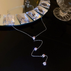 Detail of silver Y-shaped necklace with four round zircons and a teardrop pendant
