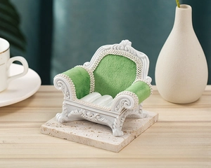 Detailed macro view of baroque mini sofa jewelry stand with green velvet and white frame