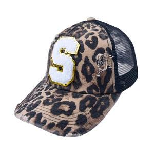 Close-up of leopard print trucker hat with S patch embroidery and sequin details