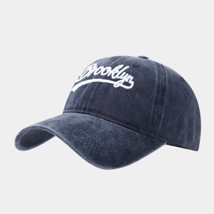 Detail of Brooklyn embroidery on a washed navy blue vintage style baseball cap