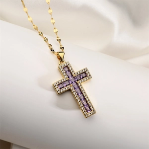 Macro detail of gold cross necklace featuring a square purple gemstone with zircon accents